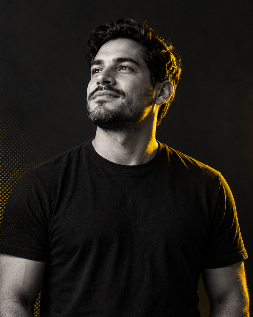 Black-and-white portrait of a man looking upward, lit with yellow rim light